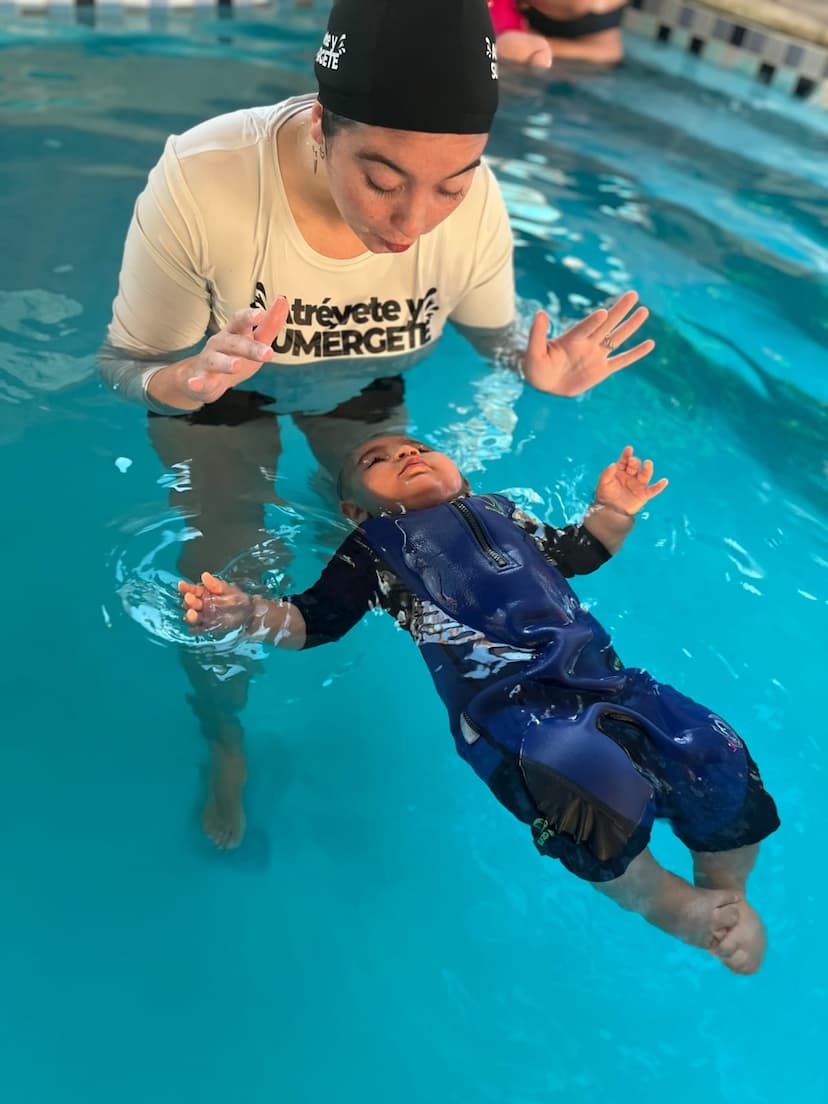 Imagen de una piscina con una mujer y un bebe