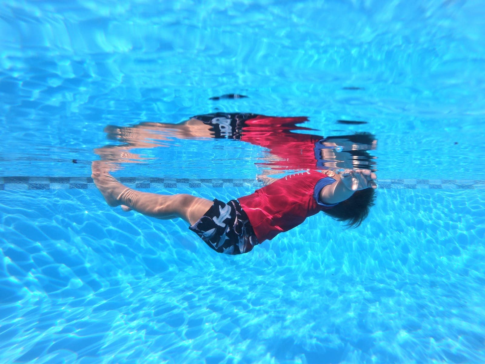 Un niño nadando feliz en una piscina